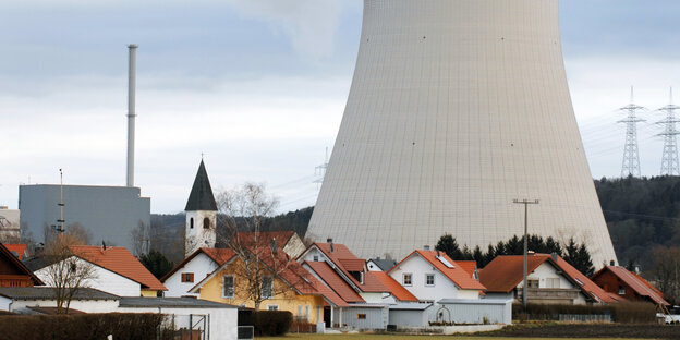 Kühlturm überragt ein Dorf Kühlturm überragt ein Dorf