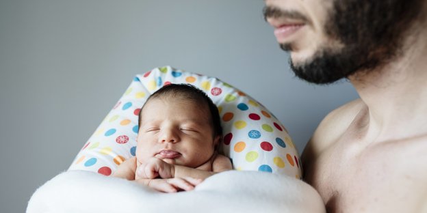 Vater mit Neugeborenem auf dem Arm