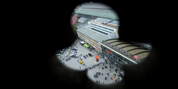Durch eine Auslassung in einer Dommauer blickt man auf den Hauptbahnhof Durch eine Auslassung in einer Dommauer blickt man auf den Hauptbahnhof