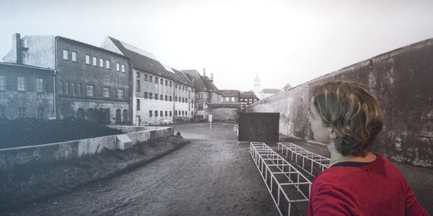 Eine Frau steht vor einem Foto der Gedenkstätte Torgau Eine Frau steht vor einem Foto der Gedenkstätte Torgau