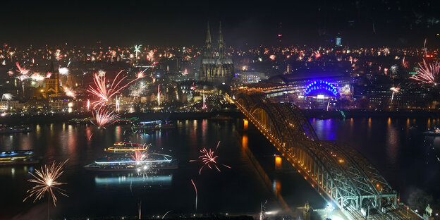 Luftaufnahme des Rheinufers in Köln mit dem Dom bei Nacht, in der Luft ist Feuerwerk Luftaufnahme des Rheinufers in Köln mit dem Dom bei Nacht, in der Luft ist Feuerwerk