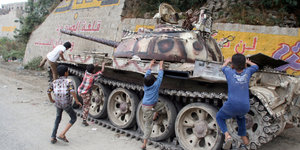 Kinder klettern auf einem Panzer rum