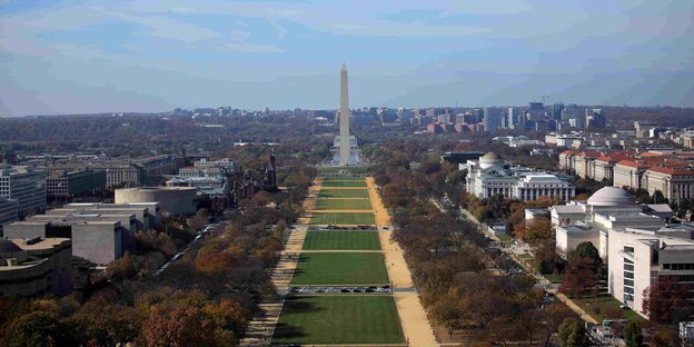 als grüner Streifen erstreckt sich die National Mall vor blassblauem Himmel als grüner Streifen erstreckt sich die National Mall vor blassblauem Himmel