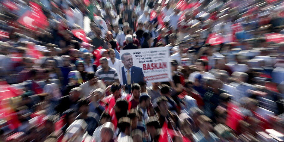 Flu bir insan topluluğu içinde bir Erdoğan afişi