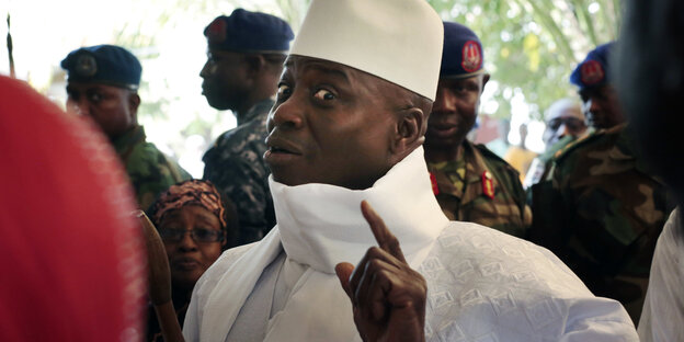 Gambias abgewählter Präsident Yahya Jammeh hebt den Zeigefinger und lacht schelmisch Gambias abgewählter Präsident Yahya Jammeh hebt den Zeigefinger und lacht schelmisch