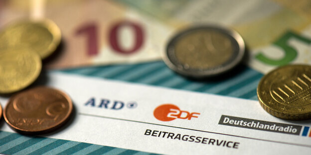 Münzen liegen auf einer Rechnung für den Rundfunkbeitrag Münzen liegen auf einer Rechnung für den Rundfunkbeitrag