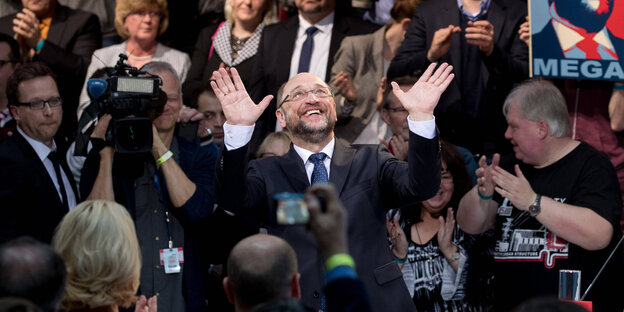Umringt von Menschen hebt Martin Schulz beide Hände hoch Umringt von Menschen hebt Martin Schulz beide Hände hoch