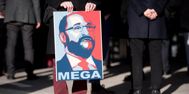 Jemand hält ein Plakat mit einem Bild des SPD-Kanzlerkandidaten Martin Schulz und dem Wort "Mega" Jemand hält ein Plakat mit einem Bild des SPD-Kanzlerkandidaten Martin Schulz und dem Wort "Mega"