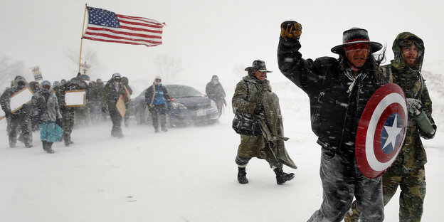 Menschen demonstrieren mit einer US-Flagge in vielen Schnee Menschen demonstrieren mit einer US-Flagge in vielen Schnee