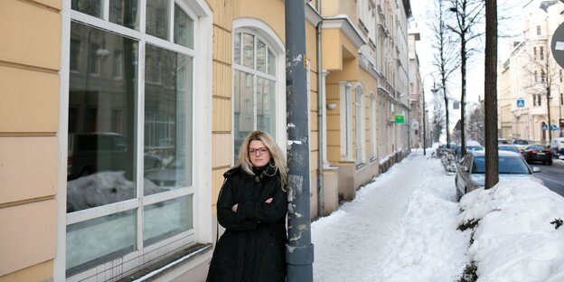 Susanne Schaper steht an eine Laterne angelehnt auf dem zugeschneiten Bürgersteig einer Straße Susanne Schaper steht an eine Laterne angelehnt auf dem zugeschneiten Bürgersteig einer Straße