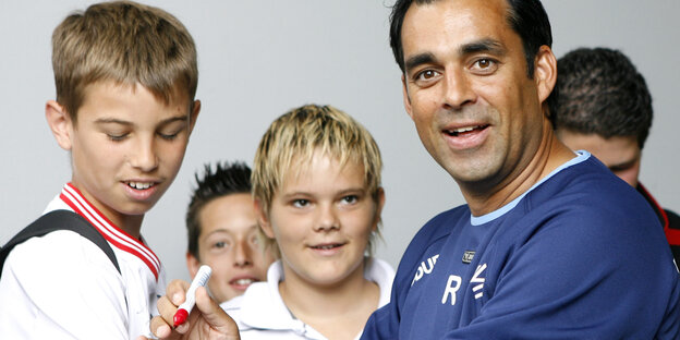 Robin Dutt, zusammen mit mehreren Kindern. Er hält einen Eddingstift in der Hand Robin Dutt, zusammen mit mehreren Kindern. Er hält einen Eddingstift in der Hand