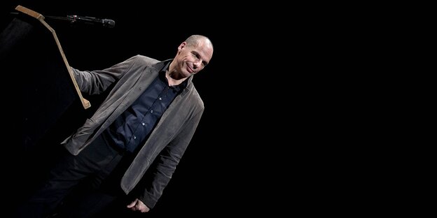 Varoufakis steht an ein Rednerpult gelehnt ganz links im Bild Varoufakis steht an ein Rednerpult gelehnt ganz links im Bild