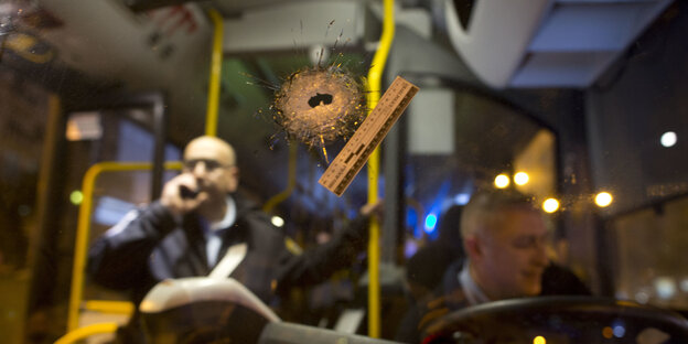 Die Windschutzscheibe eines Busses weist ein Einschußloch auf