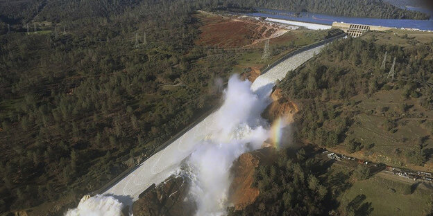 Wasser fließt von einem Stausee an einem Hügel herunter Wasser fließt von einem Stausee an einem Hügel herunter