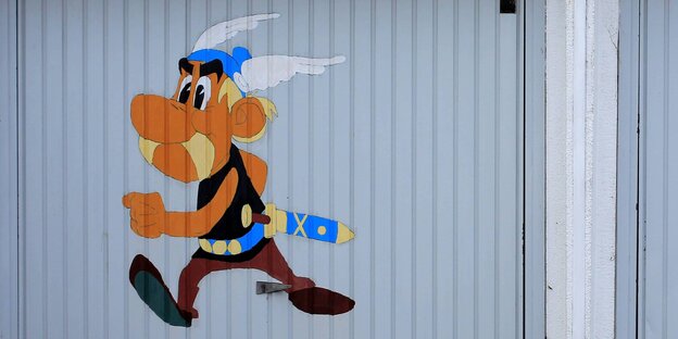 Auf ein Garagentor ist das Abbild der Comicfigur Asterix aufgemalt Auf ein Garagentor ist das Abbild der Comicfigur Asterix aufgemalt