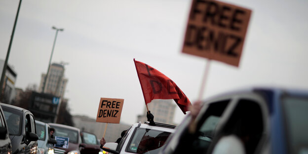 Menschen halten "Free Deniz"-Schilder aus den Autofenstern Menschen halten "Free Deniz"-Schilder aus den Autofenstern