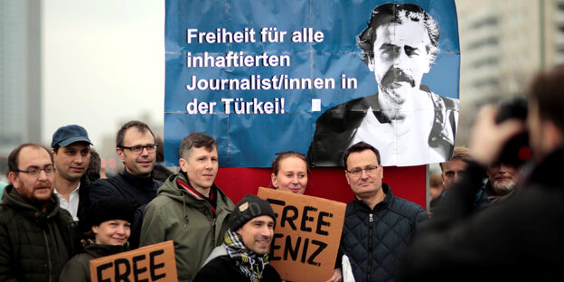 Mit Plakaten posieren ProtestteilnehmerInnen für ein Foto Mit Plakaten posieren ProtestteilnehmerInnen für ein Foto