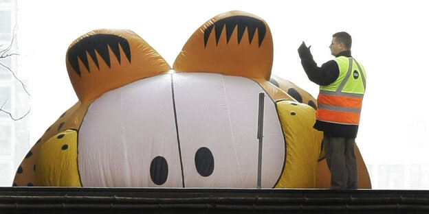 Riesiger Luftballon in Garfield-Form taucht hinter Dach auf Riesiger Luftballon in Garfield-Form taucht hinter Dach auf