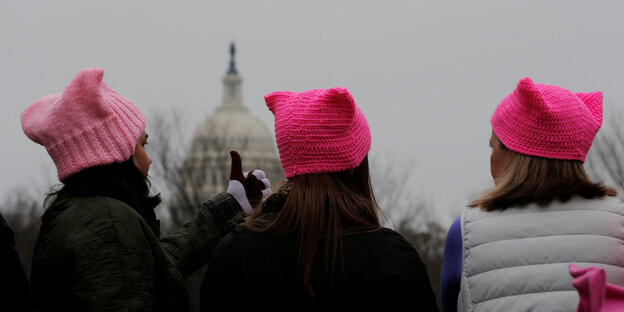 Drei Frauen mit rosa Mützen sitzen vor dem Kapitol in Washington Drei Frauen mit rosa Mützen sitzen vor dem Kapitol in Washington