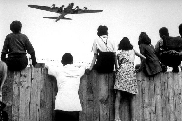 Kinder sitzen 1948 auf dem Zaun des Flughafens Tempelhof, während ein Rosinenbomber der US-Luftstreitkräfte zur Landung ansetzt Kinder sitzen 1948 auf dem Zaun des Flughafens Tempelhof, während ein Rosinenbomber der US-Luftstreitkräfte zur Landung ansetzt