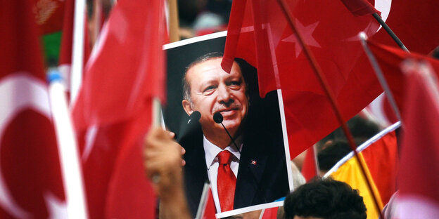 Türkische Fahnen, dazwischen ein Porträtbild Erdogans Türkische Fahnen, dazwischen ein Porträtbild Erdogans