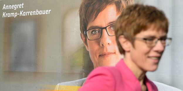 Eine Frau vor einem Wahlplakat. Es ist Annegret Kramp-Karrenbauer Eine Frau vor einem Wahlplakat. Es ist Annegret Kramp-Karrenbauer
