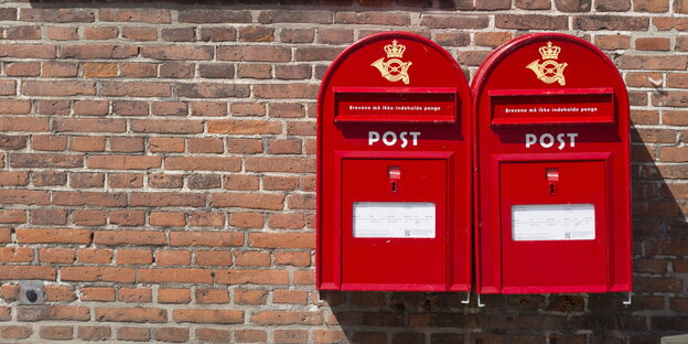zwei rote Briefkästen an einer Klinkerwand zwei rote Briefkästen an einer Klinkerwand
