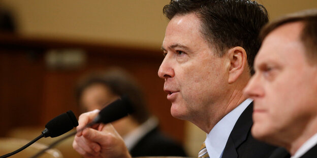James Comey spricht in ein Mikrofon James Comey spricht in ein Mikrofon