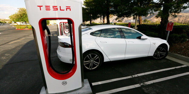 Ein Tesla an einer Stromtankstelle Ein Tesla an einer Stromtankstelle