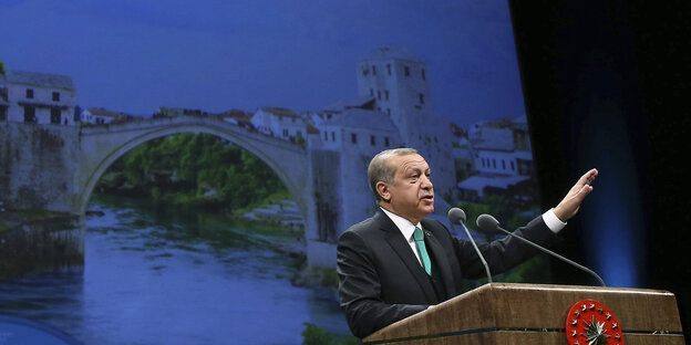 Recep Tayyip Erdoğan steht hinter einem Rednerpult und hebt den linken Arm in die Höhe Recep Tayyip Erdoğan steht hinter einem Rednerpult und hebt den linken Arm in die Höhe