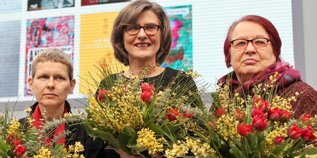 drei Frauen mit Blumensträußen