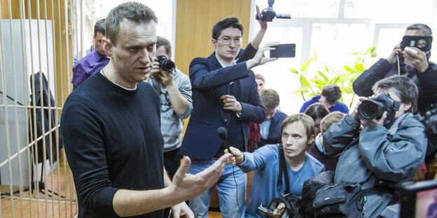 Alexei Nawalny steht in einem Gerichtssaal umringt von Journalisten Alexei Nawalny steht in einem Gerichtssaal umringt von Journalisten