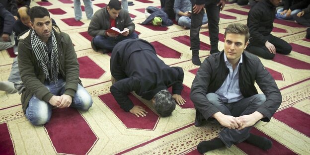 Mehrere Männer auf dem Boden einer Moschee Mehrere Männer auf dem Boden einer Moschee