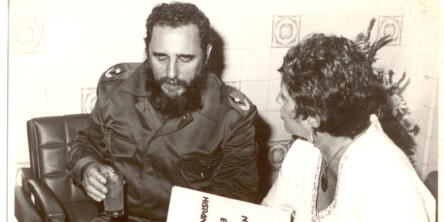 Ein schwarz-weiß Bild, auf dem sich ein Mann in Militäruniform mit einer Frau mit kurzen Haaren unterhält Ein schwarz-weiß Bild, auf dem sich ein Mann in Militäruniform mit einer Frau mit kurzen Haaren unterhält
