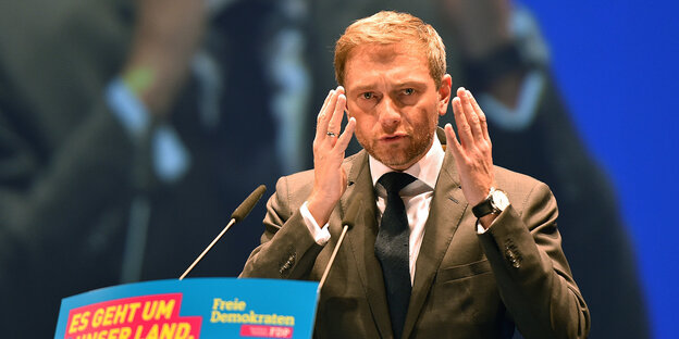 Christian Lindner spricht an einem Podium und gestikuliert dabei mit den Händen