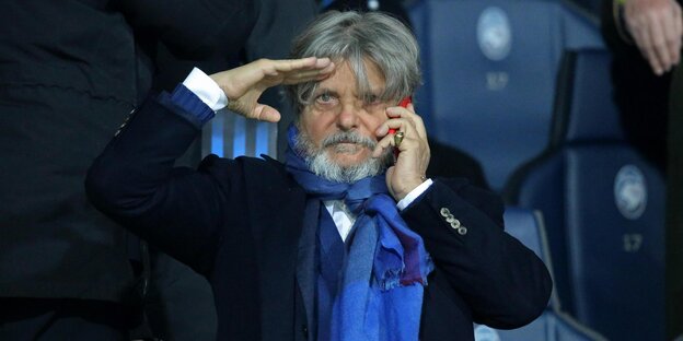 Massimo Ferrero hat die eine Hand zum militärischen Gruß erhoben, mit der anderen hält er sich sein Telefon ans Ohr Massimo Ferrero hat die eine Hand zum militärischen Gruß erhoben, mit der anderen hält er sich sein Telefon ans Ohr
