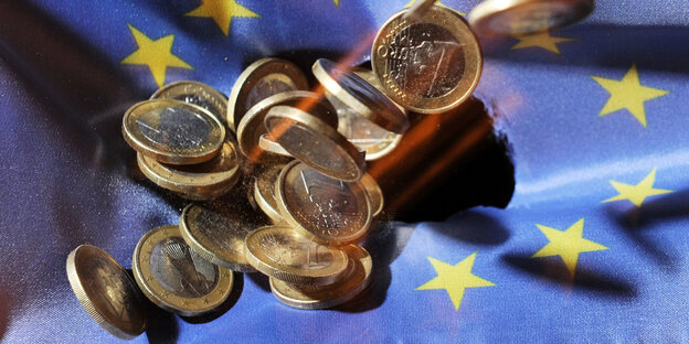 Euromünzen auf einer Europa-Flagge Euromünzen auf einer Europa-Flagge