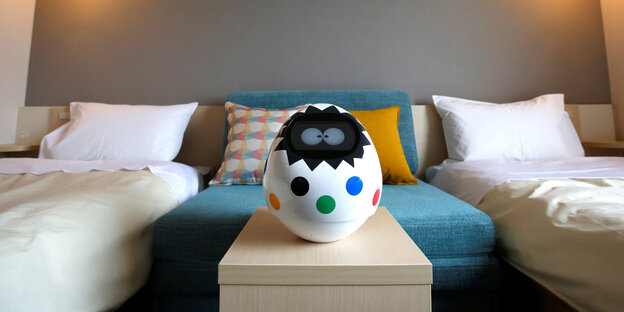 Ein buntes Plastikei mit Augen steht in einem Hotelzimmer Ein buntes Plastikei mit Augen steht in einem Hotelzimmer