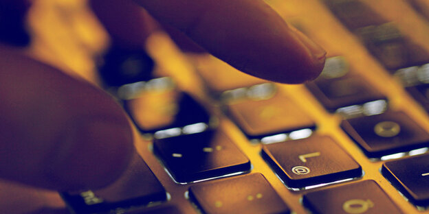 Eine Hand über einer Computertastatur Eine Hand über einer Computertastatur