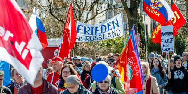 Zwischen Friedensfahnen wehen Transparente wie "Frieden mit Russland". Zwischen Friedensfahnen wehen Transparente wie "Frieden mit Russland".