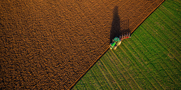 Ein Traktor pflügt ein Feld um