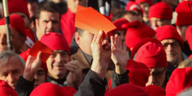 Eine Menge von Menschen, die rote Mützen tragen Eine Menge von Menschen, die rote Mützen tragen
