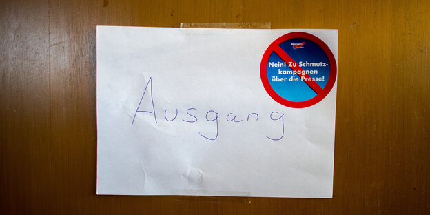 An einer Tür hängt ein Zettel mit der Aufschrift „Ausgang“ und einem AfD-Aufkleber „Nein zu Schmutzkampangnen über die Presse“ An einer Tür hängt ein Zettel mit der Aufschrift „Ausgang“ und einem AfD-Aufkleber „Nein zu Schmutzkampangnen über die Presse“