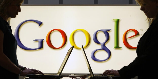 Zwei Laptops vor einem Google Logo Zwei Laptops vor einem Google Logo