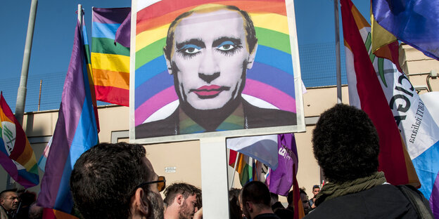 Demonstranten in Rom tragen ein Porträt von Wladimir Putin in Regenbogenfarben Demonstranten in Rom tragen ein Porträt von Wladimir Putin in Regenbogenfarben