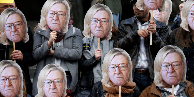 Aktivist_innen halten Masken vor ihre Gesichter, auf denen Jean-Marie Le Pens Gesicht mit den Haaren seiner Tochter zu sehen ist Aktivist_innen halten Masken vor ihre Gesichter, auf denen Jean-Marie Le Pens Gesicht mit den Haaren seiner Tochter zu sehen ist