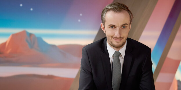 Ein Mann im Anzug vor buntem Hintergrund Ein Mann im Anzug vor buntem Hintergrund