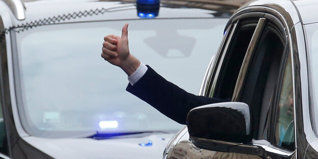 Eine Hand aus einem Autofenster zeigt den „Daumen hoch“ Eine Hand aus einem Autofenster zeigt den „Daumen hoch“
