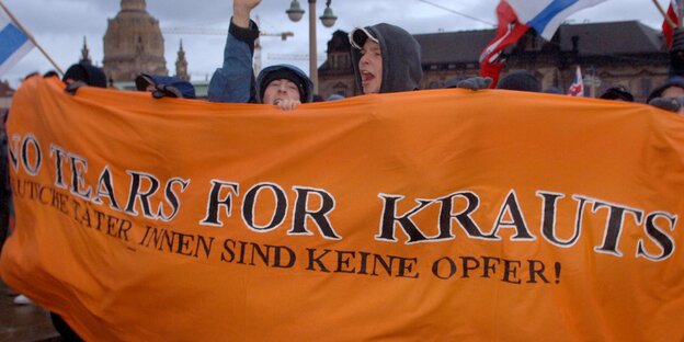 Menschen halten ein Transparent "No Tears for Krauts - Deutsche Täter_innen sind keine Opfer" Menschen halten ein Transparent "No Tears for Krauts - Deutsche Täter_innen sind keine Opfer"