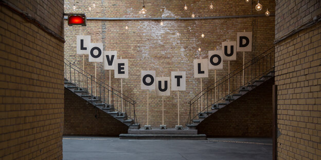 An einer Wand steht "Love Out Loud" An einer Wand steht "Love Out Loud"